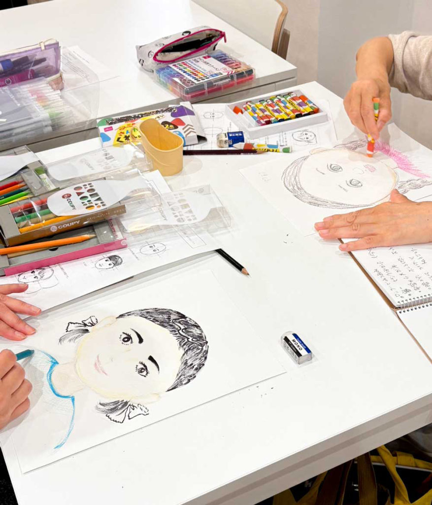 はじめの一歩コース・木曜で、生徒さんがお互いに子供の頃の顔を想像しながら似顔絵を描いている様子。